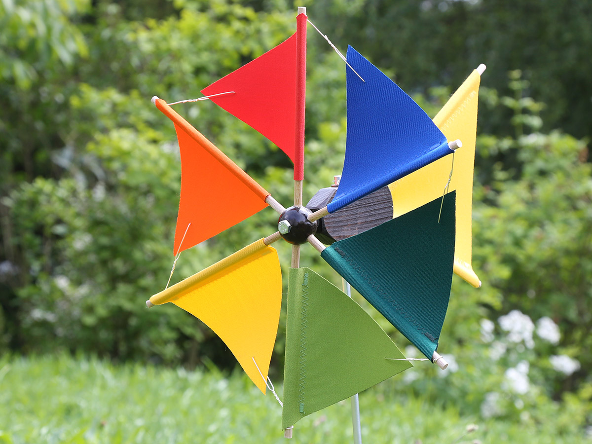 Leuchtend rotes Windrad als Blickfang im Garten